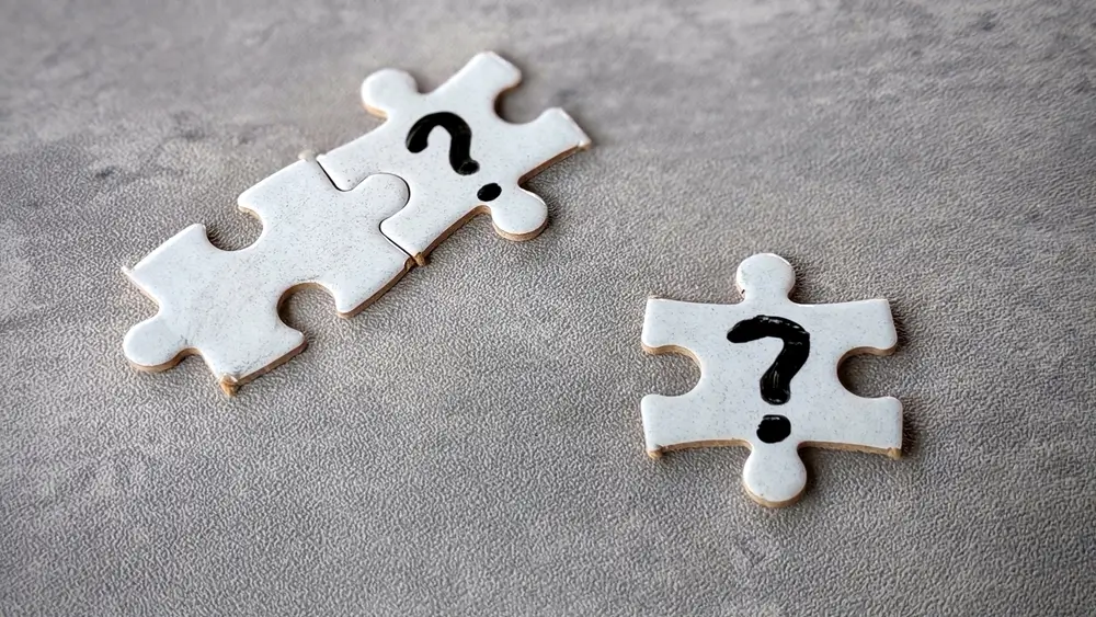 Pièces de puzzle avec points d'interrogation illustrant le raisonnement abstrait et la recherche de schémas logiques.