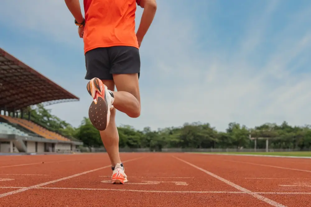 Un coureur sur une piste d'athlétisme effectue un test navette pour évaluer son endurance et son VO2 Max.