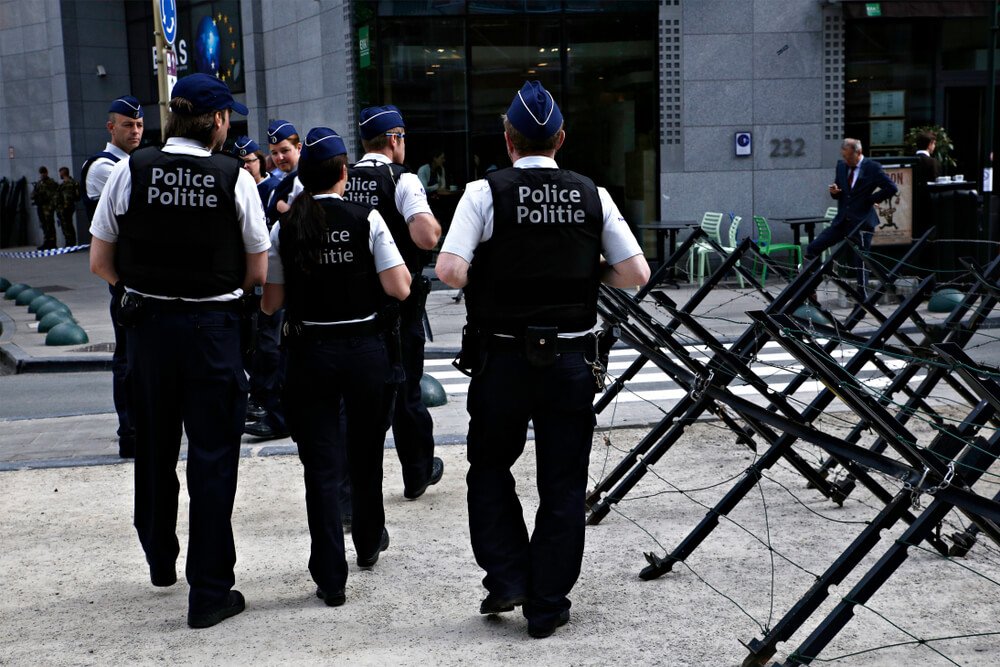 Meerdere Belgische politieagenten op patrouille in een stadswijk tijdens een ordedienst.