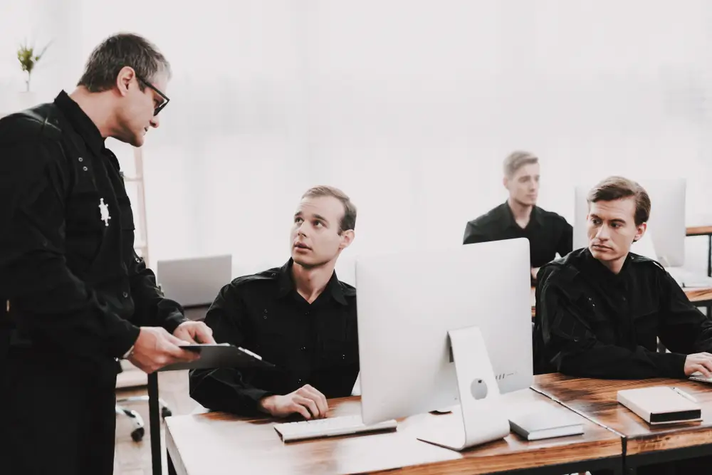 Politierekruten in opleiding aan de ANPA luisteren naar instructies in een computerlokaal.