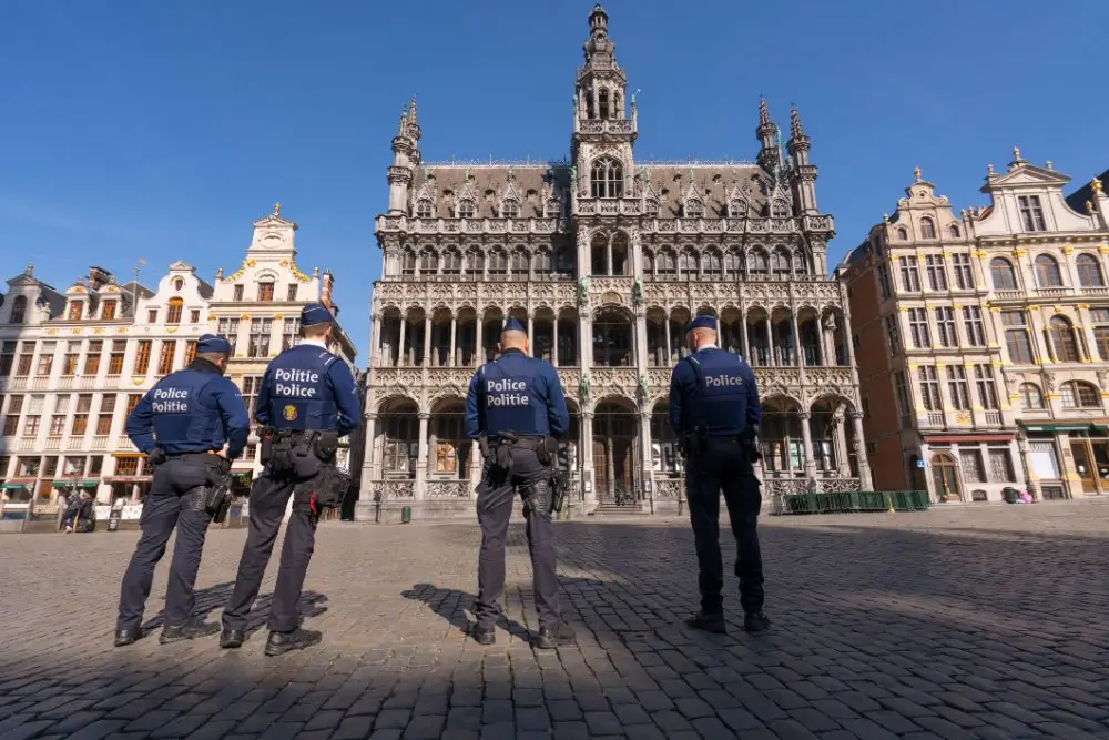 Vier Belgische politieambtenaren in uniform tijdens een interventiepatrouille op het terrein in Brussel.