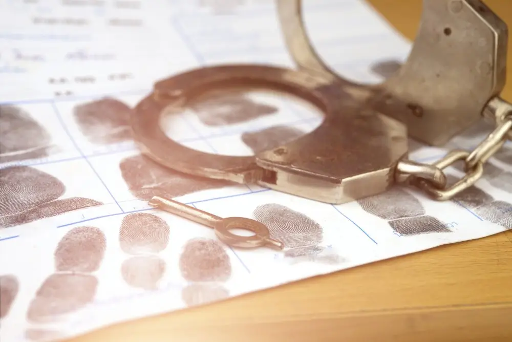 Menottes et clé sur une fiche d'empreintes digitales, matériel représentatif de l'équipement policier.