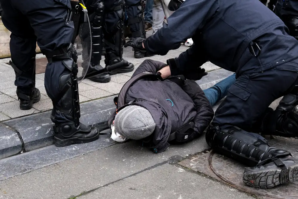Inspecteur de police en patrouille lors d'une intervention urbaine pour immobiliser un individu sur la voie publique.