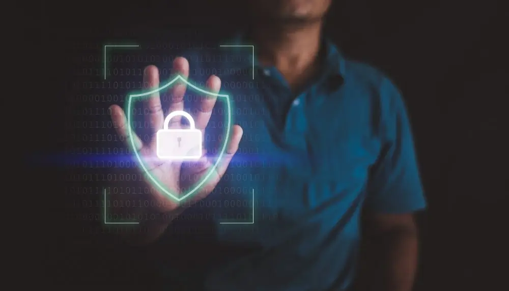 Hand die een digitaal hangslot en schild aanraakt voor cyberveiligheid en gegevensbescherming.