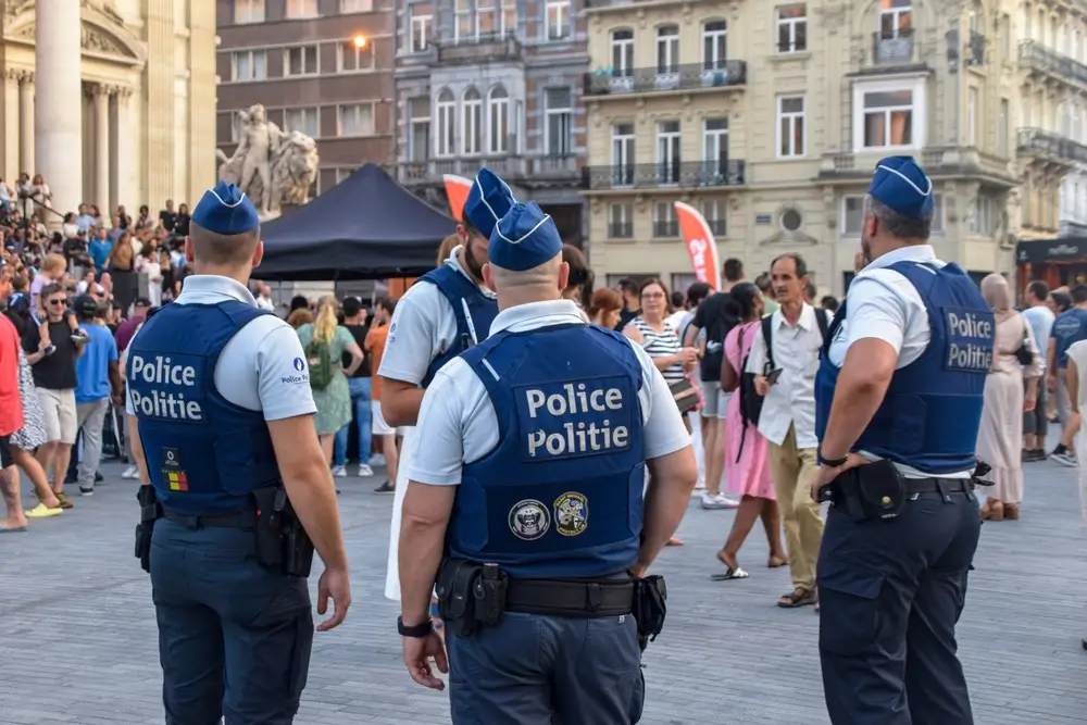 Belgische politie-inspecteurs in uniform tijdens een wijkpatrouille in contact met de burgers.
