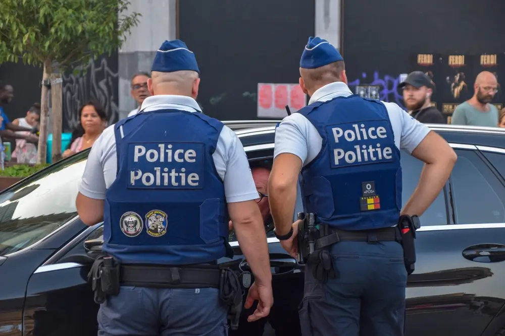 Policier en uniforme discutant avec des habitants devant leur domicile lors d'une médiation de voisinage
