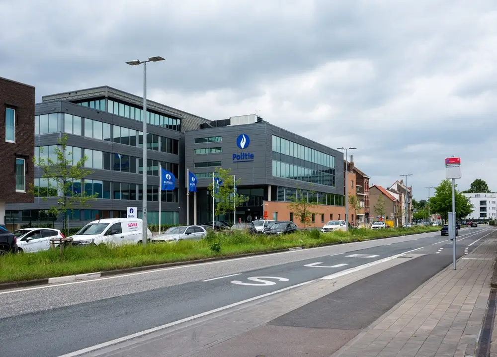Siège de la police belge, bâtiment institutionnel moderne avec entrée sécurisée et logo Politie bien visible.