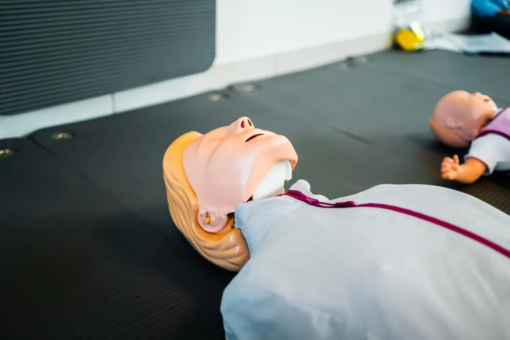 Reanimatiepoppen op oefenmatten voor een praktijkoefening eerste hulp tijdens een professionele veiligheidsopleiding.