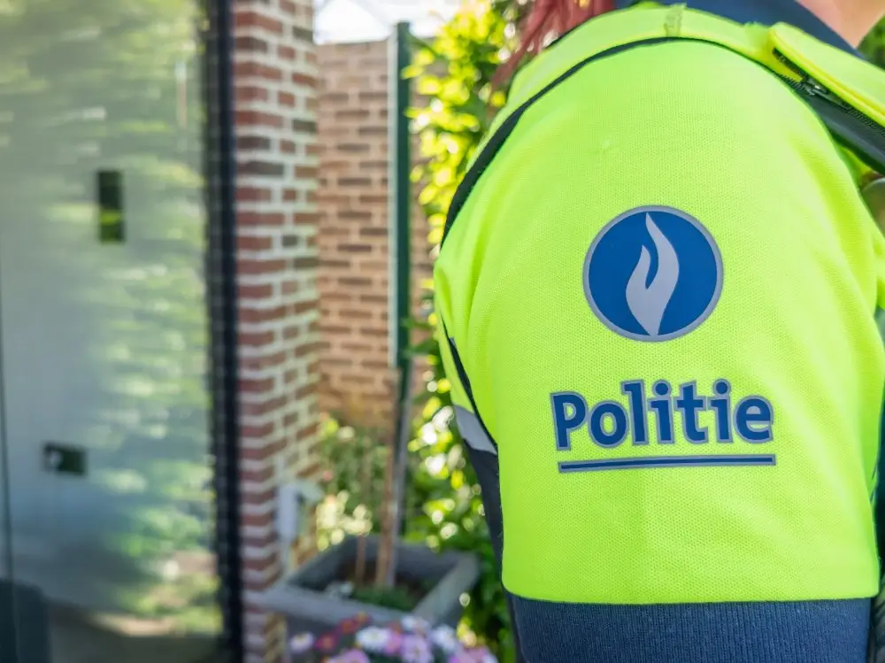 Gros plan sur l'uniforme d'un policier belge évoquant la promotion et l'évolution de grade au sein de la police.