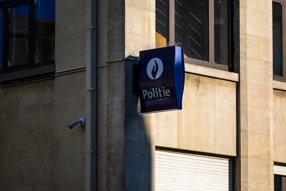 Enseigne bleue de la police avec logo sur la façade d'un commissariat, bâtiment de l'administration policière locale.