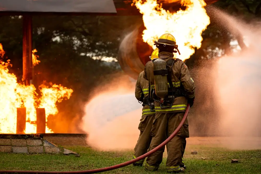 Brandweerlieden tijdens een interventie met een waterstraal om een gebouwbrand te blussen tijdens een trainingsoefening.