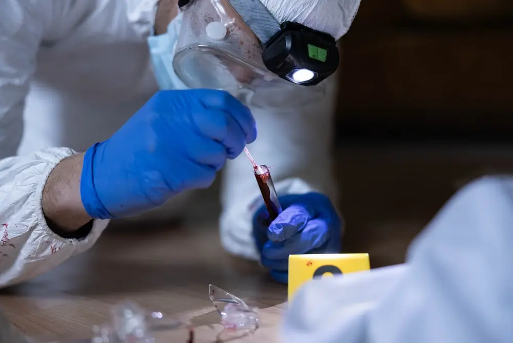 Deskundige van de technische politie die een biologisch staal afneemt voor forensisch DNA-onderzoek op de plaats delict.