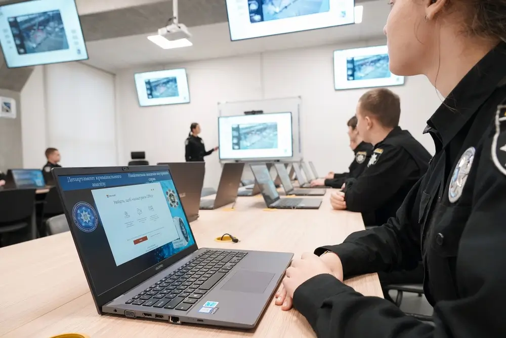 Aspirant-politieambtenaren tijdens een beroepsopleiding in een leslokaal van de politieacademie uitgerust met computers.