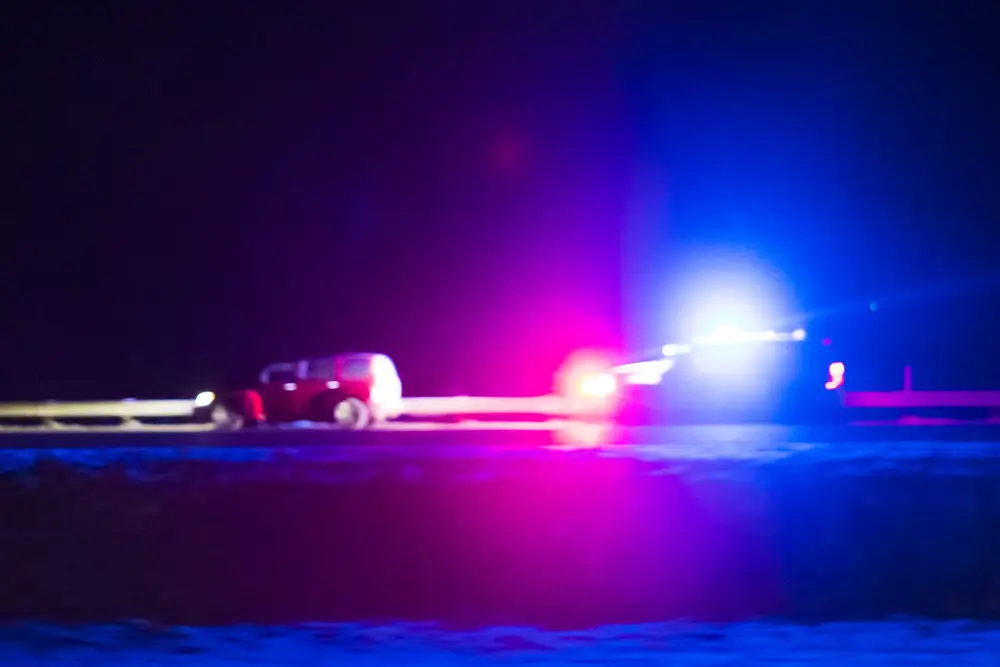 Politievoertuig van de Wegpolitie tijdens een nachtelijke snelheidscontrole met zwaailichten op de snelweg.