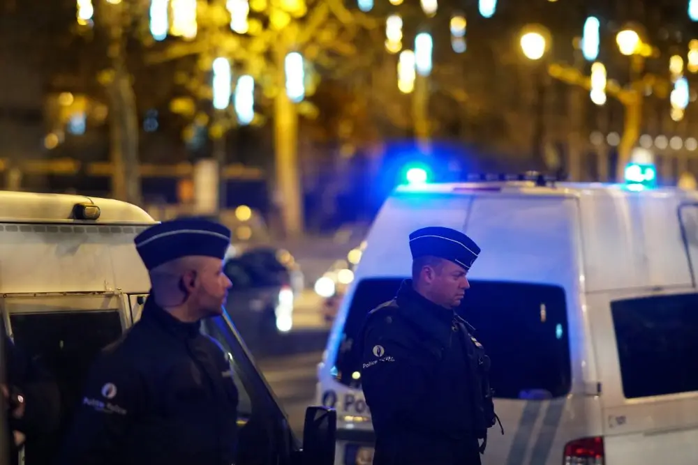 Patrouille policière en rue urbaine lors d'une intervention de terrain nocturne devant des véhicules de police.