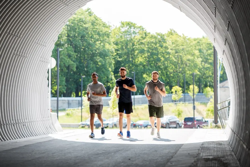 Drie mannen lopen samen als voorbereiding op een fysieke proef